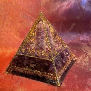 In deze Organiet Piramide is Rozenkwarts verwerkt. Deze mooie roze edelsteen is een veelzijdige steen die niet alleen mooi is om te zien, maar ook krachtige helende eigenschappen bezit. Ze staat symbool voor universele liefde, onvoorwaardelijke acceptatie en emotionele verzachting. Zeer geschikt in rituelen rondom zelfheling, hartopeningen of het aantrekken van liefdevolle energie. Plaats rozenkwarts in een ruimte om een liefdevolle, kalme en harmonieuze sfeer te creëren, want ze schept een gevoel van vrede en sereniteit in de omgeving. De kalmerende werking van Rozenkwarts maakt het een uitstekende steen bij stress, angst, boosheid of verdriet. Het brengt geestelijke rust en emotionele balans en helpt je om spanningen los te laten. Rozenkwarts hoort bij het hartchakra en staat symbool voor liefde, compassie en vergeving. . Ze wordt geassocieerd met het sterrenbeeld Stier en Kreeft. Het is een steen die symbool staat voor liefde, harmonie en kalmte, en wordt vaak gebruikt om de emoties van deze sterrenbeelden te helpen beheersen en zelfliefde te bevorderen. Rozenkwarts past ook goed bij de Weegschaal, vanwege de verbinding met Venus, de planeet die beide tekens regeert.