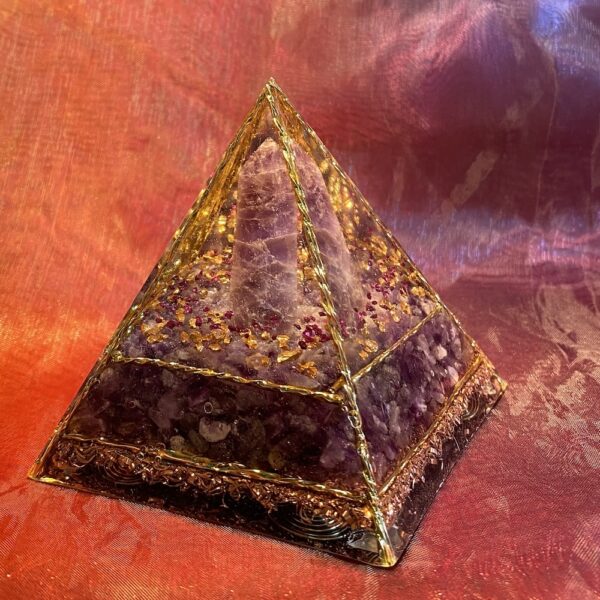 In deze Organiet Piramide is Rozenkwarts verwerkt. Deze mooie roze edelsteen is een veelzijdige steen die niet alleen mooi is om te zien, maar ook krachtige helende eigenschappen bezit. Ze staat symbool voor universele liefde, onvoorwaardelijke acceptatie en emotionele verzachting. Zeer geschikt in rituelen rondom zelfheling, hartopeningen of het aantrekken van liefdevolle energie. Plaats rozenkwarts in een ruimte om een liefdevolle, kalme en harmonieuze sfeer te creëren, want ze schept een gevoel van vrede en sereniteit in de omgeving. De kalmerende werking van Rozenkwarts maakt het een uitstekende steen bij stress, angst, boosheid of verdriet. Het brengt geestelijke rust en emotionele balans en helpt je om spanningen los te laten. Rozenkwarts hoort bij het hartchakra en staat symbool voor liefde, compassie en vergeving. . Ze wordt geassocieerd met het sterrenbeeld Stier en Kreeft. Het is een steen die symbool staat voor liefde, harmonie en kalmte, en wordt vaak gebruikt om de emoties van deze sterrenbeelden te helpen beheersen en zelfliefde te bevorderen. Rozenkwarts past ook goed bij de Weegschaal, vanwege de verbinding met Venus, de planeet die beide tekens regeert.